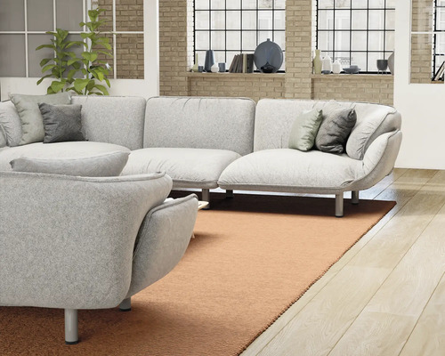 Salon lumineux avec un grand canapé, un fauteuil et un tapis