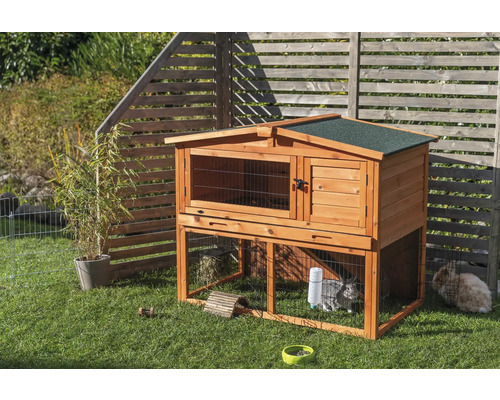 Clapier à lapins en bois à deux étages avec deux lapins dans le jardin