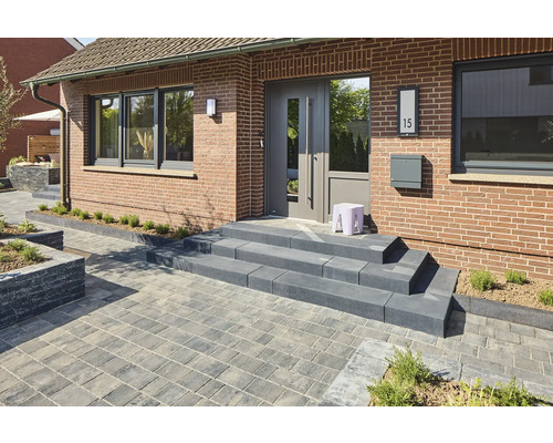 Aussenaufnahme eines Hauses mit Pflastersteinen, Treppe und Haustür