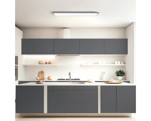 Cuisine moderne avec armoires grises, îlot de cuisine et éclairage