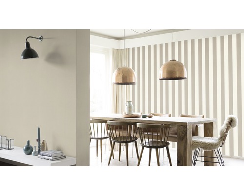 Salle à manger avec table, chaises, suspensions et papier peint rayé