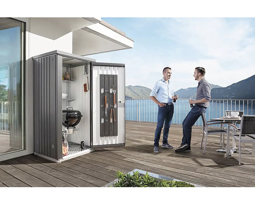 Scène avec une armoire de jardin sur une terrasse, dans laquelle sont rangés un barbecue et des accessoires, et deux personnes
