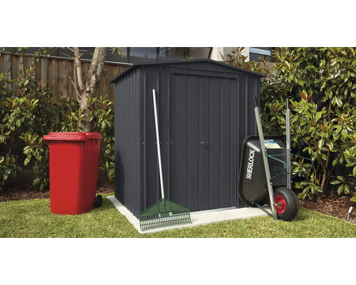 Scène de jardin avec remise, poubelle, brouette et râteau à l''extérieur.