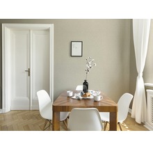 Salle à manger avec table en bois, chaises blanches et papier peint texturé