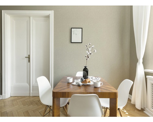 Salle à manger avec table en bois, chaises blanches et papier peint texturé