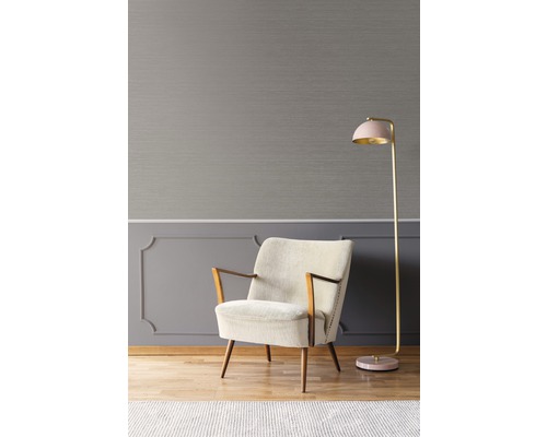 Vue intérieure avec fauteuil et lampadaire devant un mur gris