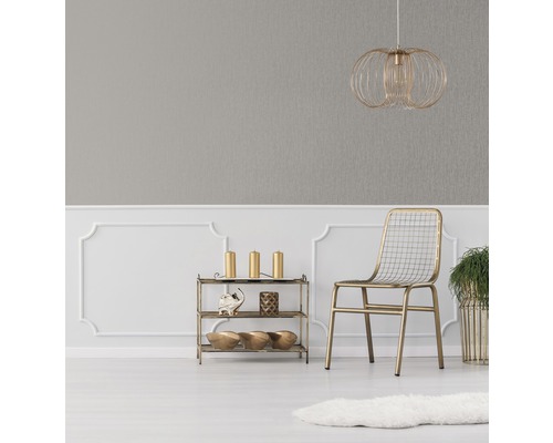 Pièce décorative avec papier peint gris, lampe dorée, chaise et étagère