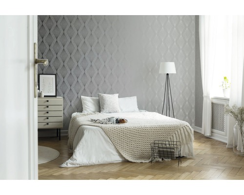 Chambre à coucher avec papier peint à motifs, lit et table de chevet