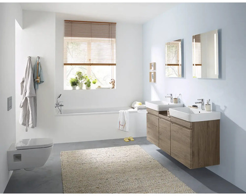 Salle de bain lumineuse avec baignoire, toilettes, lavabo et miroir