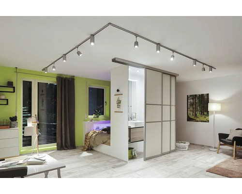 Modernes Wohnzimmer mit flexibler Beleuchtung durch ein Schienensystem mit Strahlern