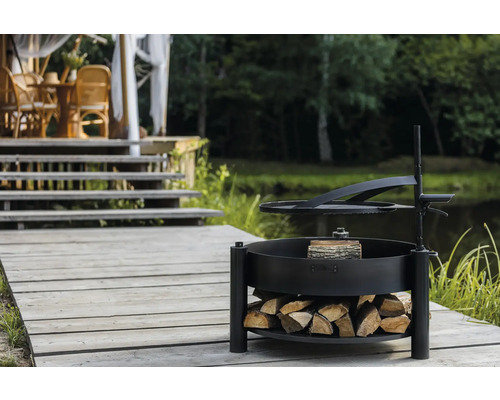 Aire de barbecue avec espace de rangement pour le bois sur une terrasse en bois près d''un étang.