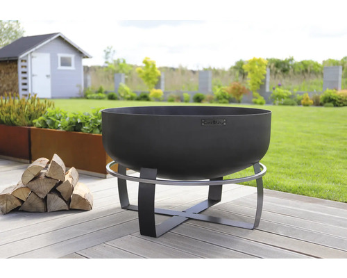 Feuerschale aus Stahl auf einem Gartenholzdeck mit Holzstapel