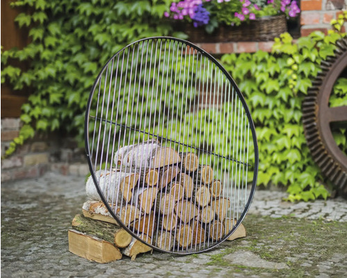 Grille ronde devant une pile de bois de chauffage