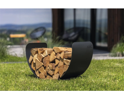 Range-bûches en métal rempli de bois de chauffage dans le jardin