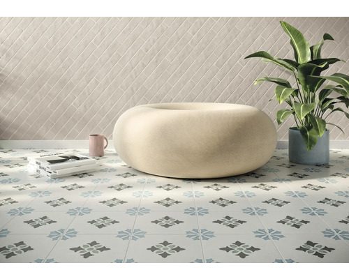 Pièce lumineuse avec carrelage décoré au sol, tabouret, plante d''intérieur et carrelage mural