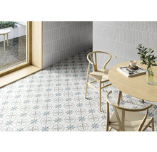Pièce lumineuse avec carrelage au sol et aux murs, table et chaises.