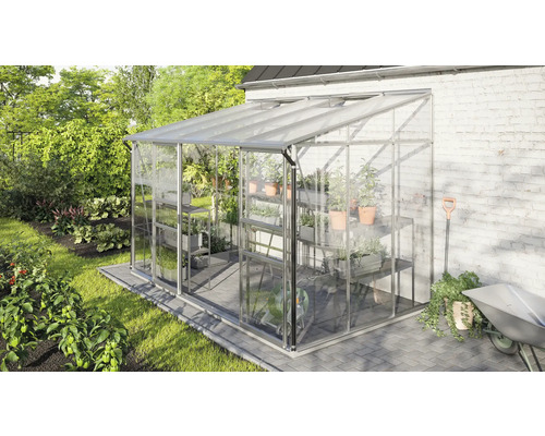Serre avec étagères, plantes et outils de jardin dans un jardin