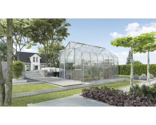 Serre de jardin avec plantations et maison en arrière-plan