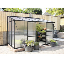 Serre avec plantes et outils de jardin à l''extérieur.