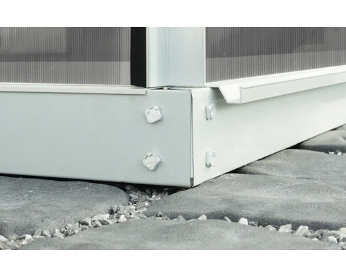 Detailansicht einer Gewächshauskonstruktion aus Metall und Glas auf einem Steinfundament