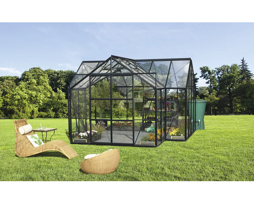 Serre avec plantes, meubles et réservoir d''eau dans le jardin