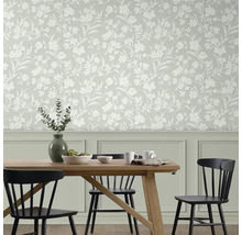 Salle à manger avec table et chaises devant un mur avec du papier peint à fleurs