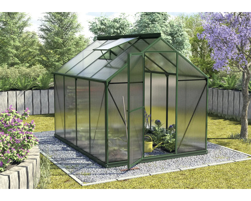 Serre avec porte ouverte et plantes dans le jardin