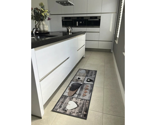 Tapis de cuisine avec motifs de cœurs sur un sol carrelé dans une cuisine moderne.