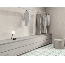 Dressing lumineux avec mur carrelé, commode, tabouret et tringle à vêtements avec vêtements