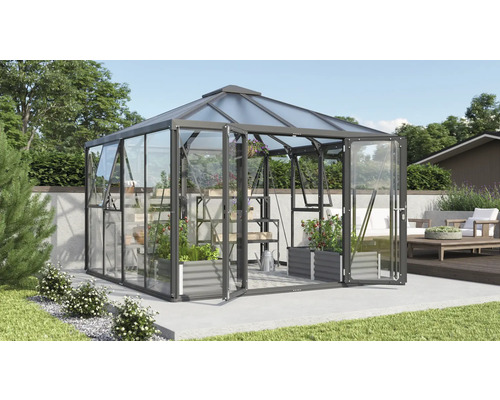 Serre avec étagères à plantes et portes ouvertes dans le jardin