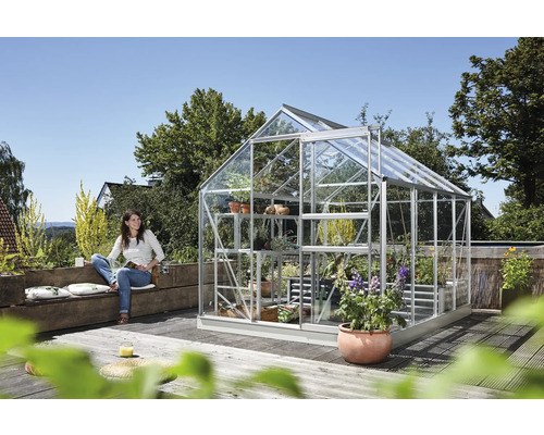 Serre avec des plantes et une femme assise sur un banc