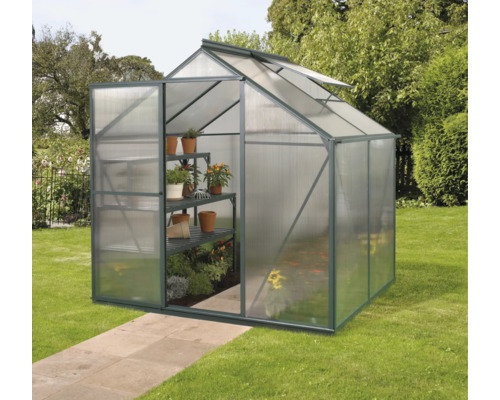 Gewächshaus mit Regalen und Pflanzen im Garten