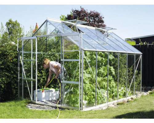 Serre de jardin avec une femme arrosant les plantes