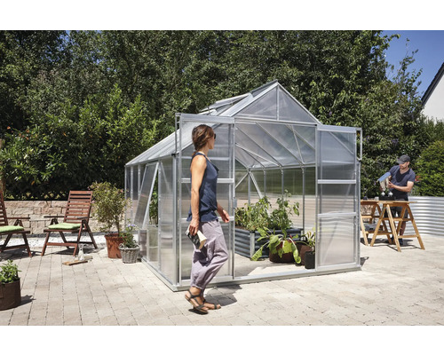 Serre avec des plantes dans le jardin et deux personnes