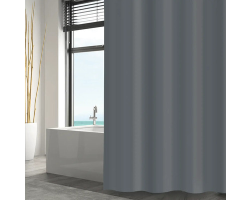 Rideau de douche gris dans la salle de bain devant la baignoire et la fenêtre.