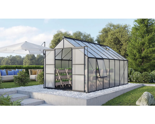Gewächshaus Vitavia Meridian 2 11500 Hohlkammerplatten 4 mm 257x445 cm schwarz Gewächshaus mit geöffneter Tür in einem Garten mit Sitzecke und Sonnenschirm