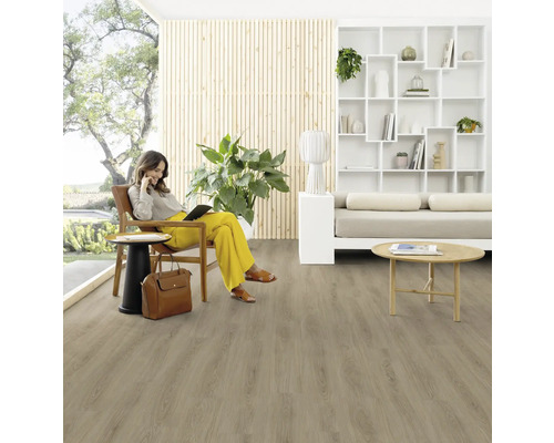 Wohnzimmer mit Holzfußboden und einer Frau, die auf einem Stuhl sitzt