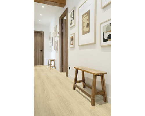 Couloir avec plancher en bois, bancs en bois et photos encadrées au mur