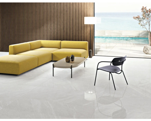 Salon lumineux avec canapé d''angle jaune, table, chaise et carrelage.
