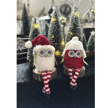 Deux hiboux décoratifs en tissu avec des bonnets de Noël et des jambes rayées sont assis sur des tranches de bois.