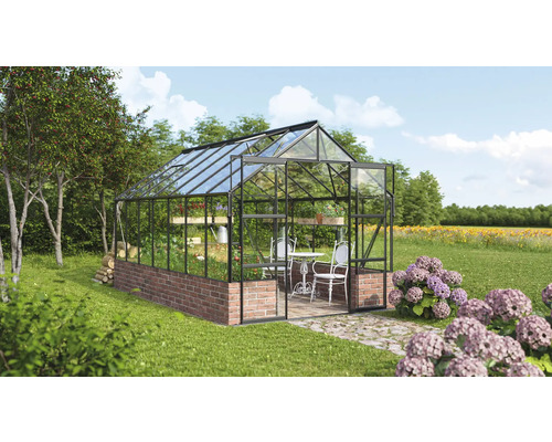 Gewächshaus mit Backsteinmauer und Glaswänden im Garten