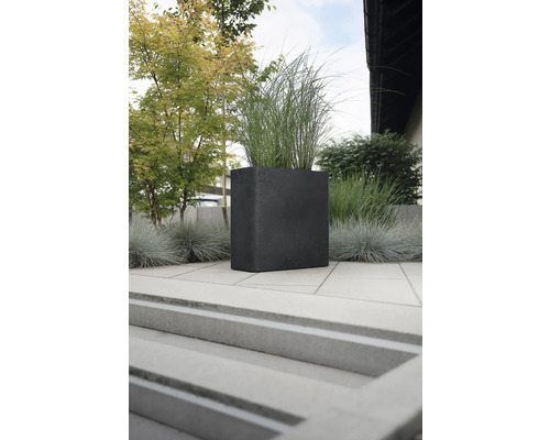 Quadratischer Pflanzkübel aus Stein mit Bepflanzung im Aussenbereich.
