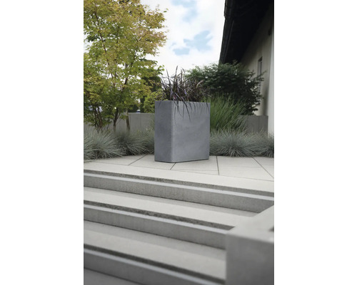 Quadratischer Pflanzkübel aus Beton im Aussenbereich auf einer Terrasse mit Treppe.