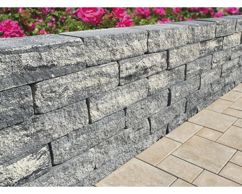 Gros plan d''un mur de jardin gris en pierres à côté de pavés