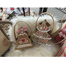 Deux sapins de Noël décoratifs en pain d''épices dans des paniers sur un fond moelleux.