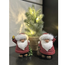 Figurines décoratives de Père Noël avec un petit sapin de Noël en arrière-plan