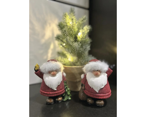 Figurines décoratives de Père Noël avec un petit sapin de Noël en arrière-plan