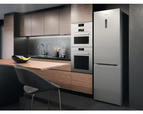 Moderne Küche mit Einbaugeräten und freistehendem Kühlschrank