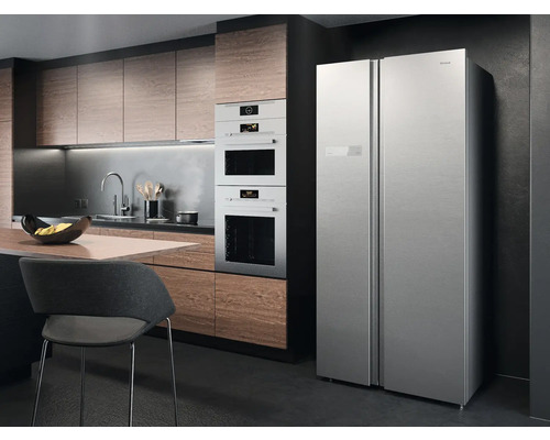 Küchenszene mit Einbauküche, Backöfen und Side-by-Side Kühlschrank