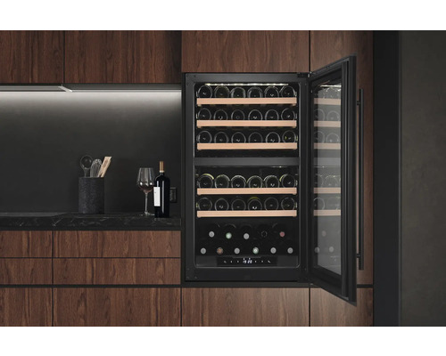 Weinkühlschrank mit geöffneter Tür in einer modernen Küche mit Holzschränken, mit mehreren Weinflaschen auf Holzregalen